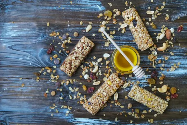 Homemade granola bars with a jar of honey